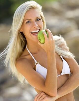 девушка ест яблоко, чтобы похудеть на 10 кг за месяц